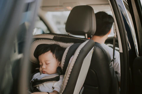 aby boy sleeping in baby seat back seat of